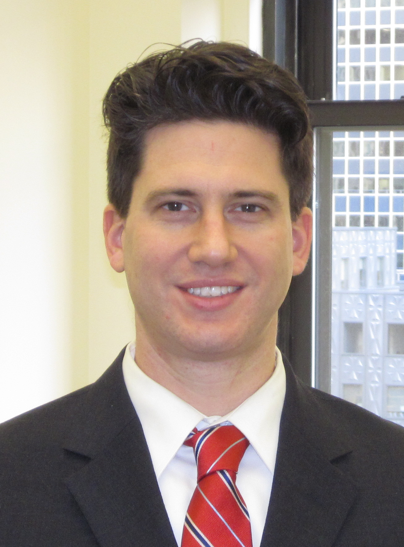 Smiling man in suit and red striped tie