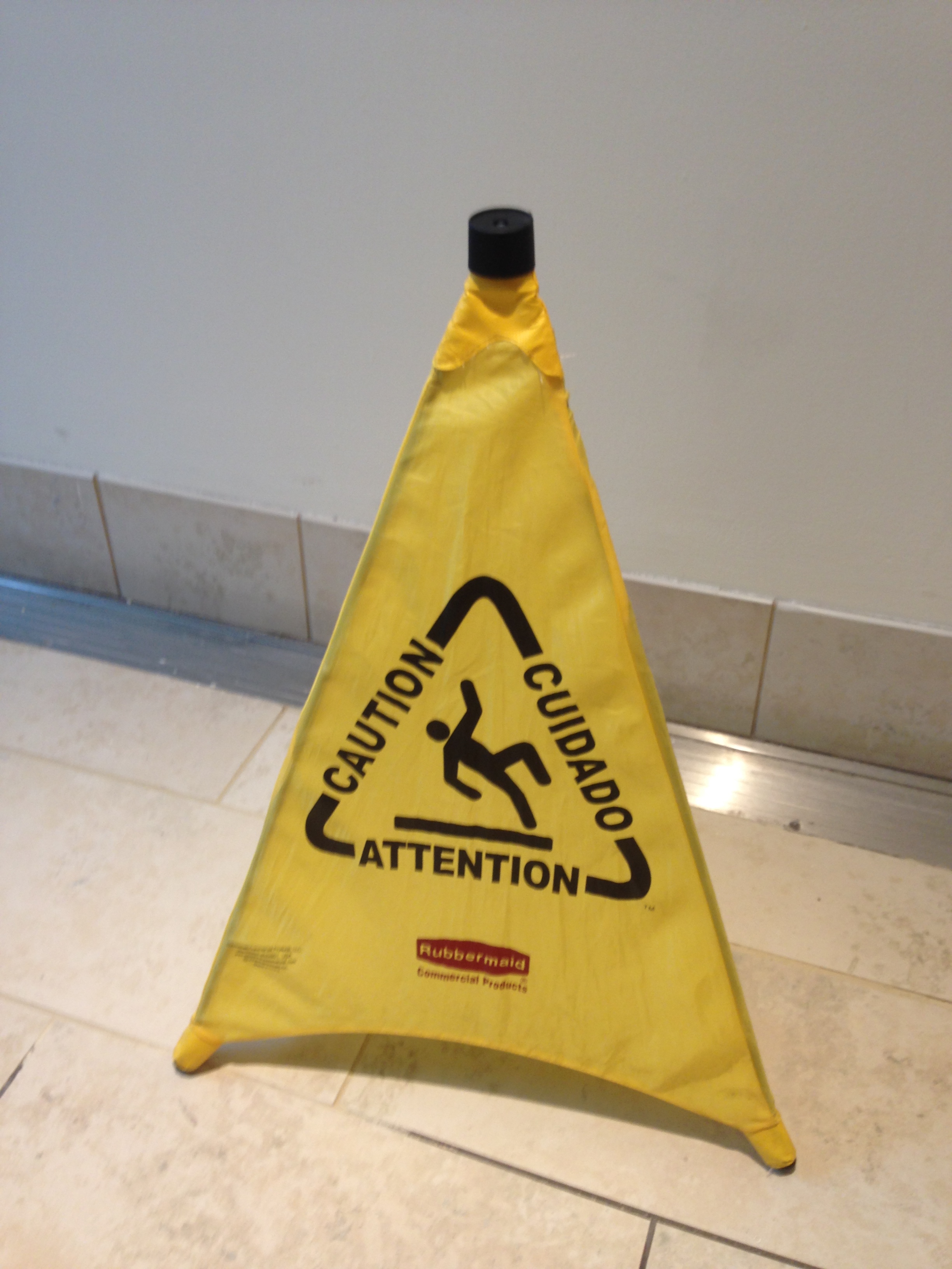 Yellow triangular wet floor caution sign